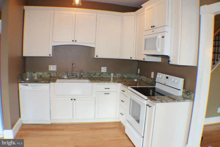 10304 Gunston Road Lorton, VA 22079 - Photo 11 of 30 a kitchen with granite countertop white cabinets and white appliances