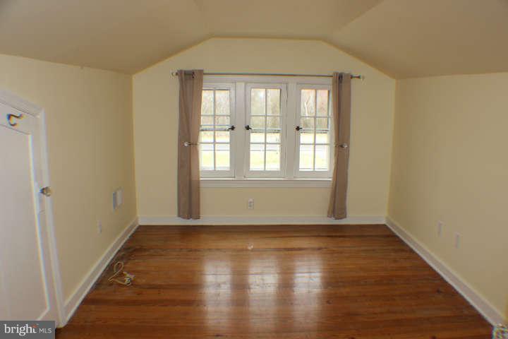 10304 Gunston Road Lorton, VA 22079 - Photo 20 of 30 a view of an empty room with wooden floor and a window
