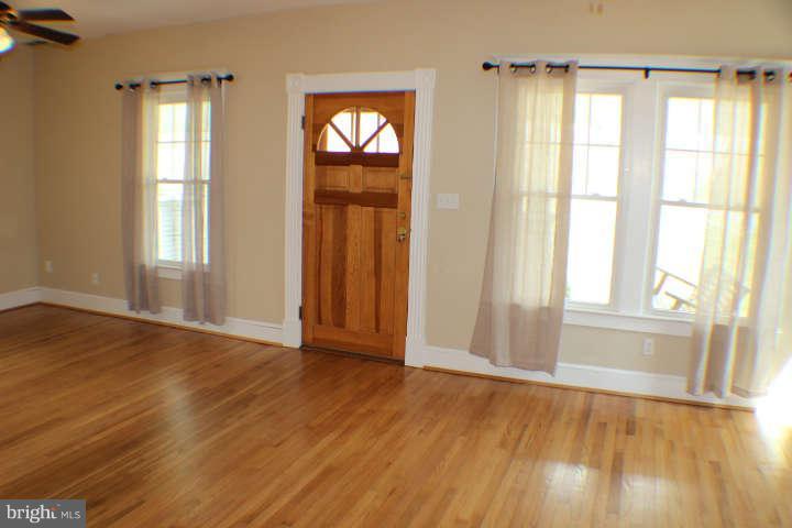 10304 Gunston Road Lorton, VA 22079 - Photo 3 of 30 an empty room with wooden floor and windows