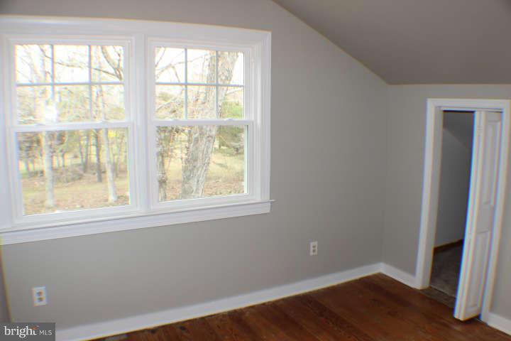 10304 Gunston Road Lorton, VA 22079 - Photo 22 of 30 an empty room with wooden floor and windows