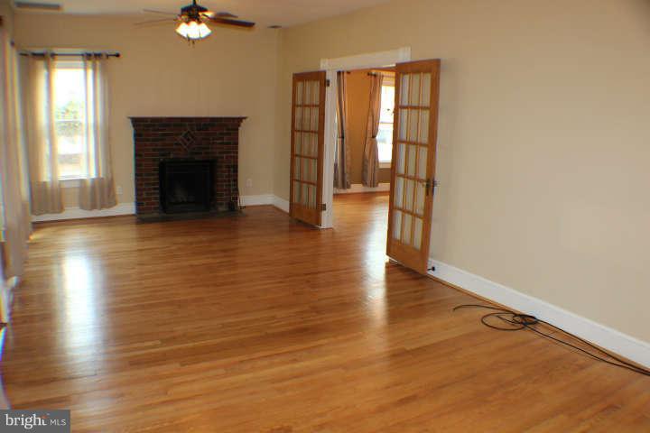 10304 Gunston Road Lorton, VA 22079 - Photo 5 of 30 an empty room with wooden floor and windows