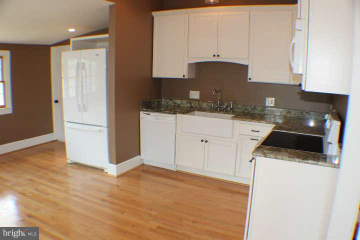 10304 Gunston Road Lorton, VA 22079 - Photo 10 of 30 a kitchen with granite countertop white cabinets and white appliances