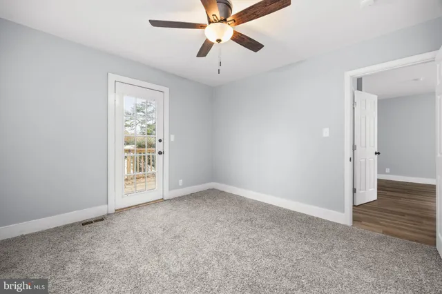 an empty room with fan and windows