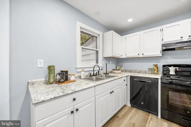 a kitchen with granite countertop a sink and cabinets