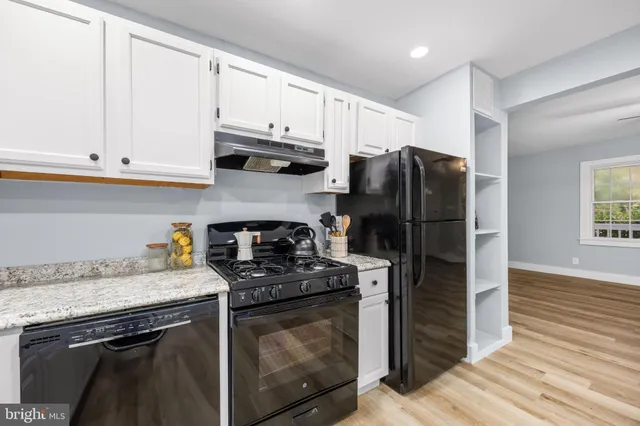 a kitchen with stainless steel appliances granite countertop a refrigerator sink and stove
