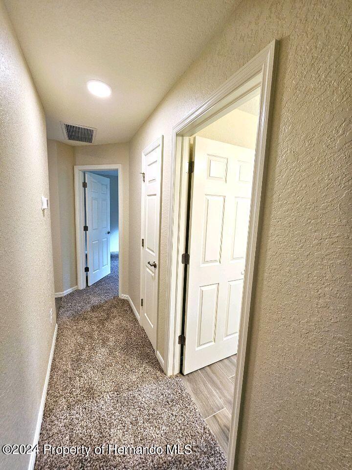 13365 Ruffed Grouse Road Weeki Wachee, FL 34614 - Photo 11 of 18 a view of a hallway with wooden floor and a bathroom