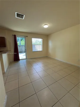 a kitchen with granite countertop wooden cabinets a stove a oven and a refrigerator with wooden floor