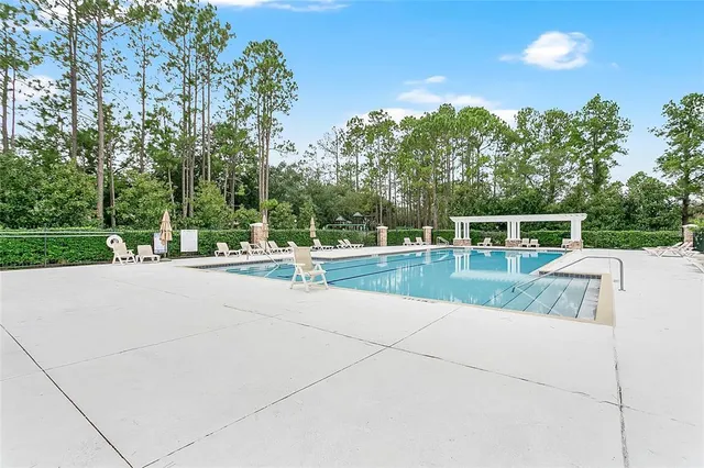 a swimming pool with a outdoor seating and a garden