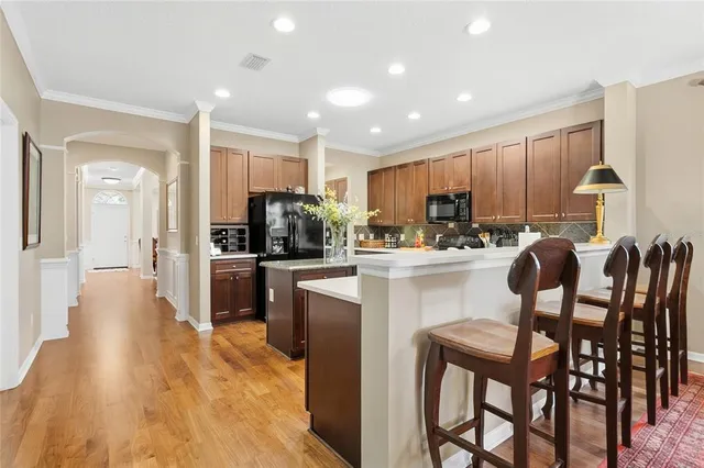 a kitchen with a dining table chairs refrigerator and cabinets
