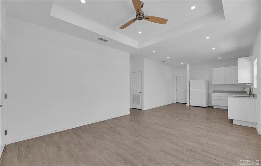 1303 Marcela Drive, Unit 4 Weslaco, TX 78599 - Photo 5 of 12 Unfurnished living room with a raised ceiling, recessed lighting, light wood finished floors, and a ceiling fan