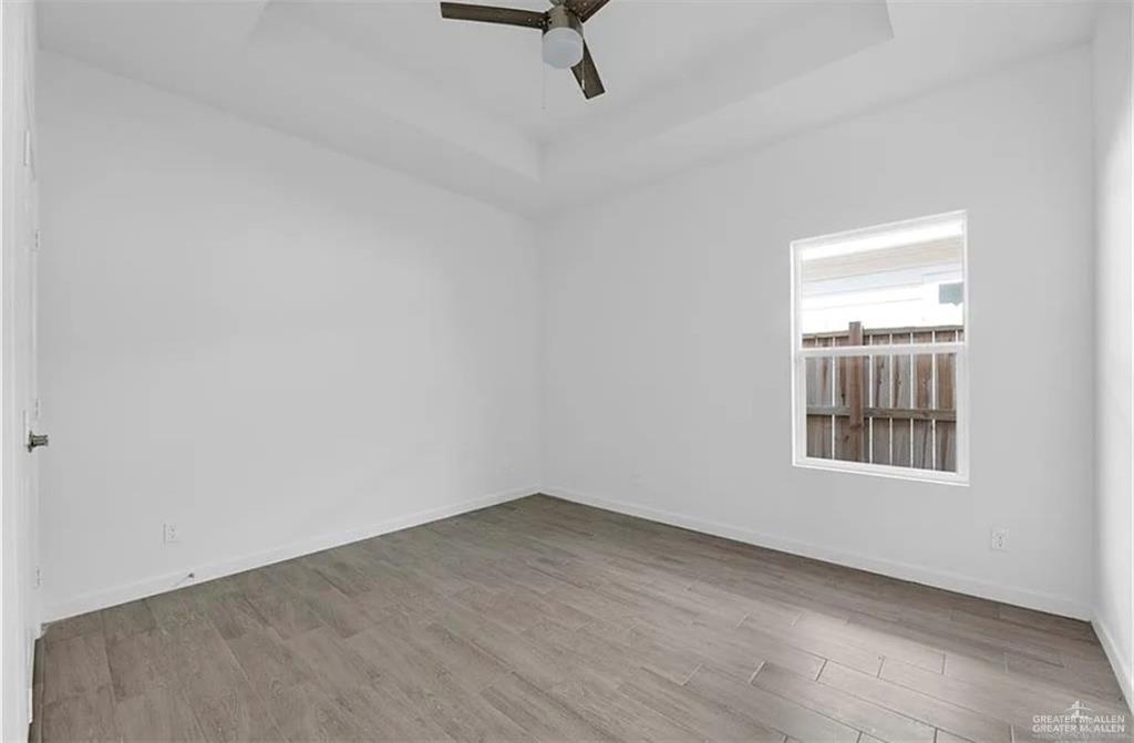 1303 Marcela Drive, Unit 4 Weslaco, TX 78599 - Photo 8 of 12 Spare room featuring a tray ceiling, light wood-style floors, and ceiling fan