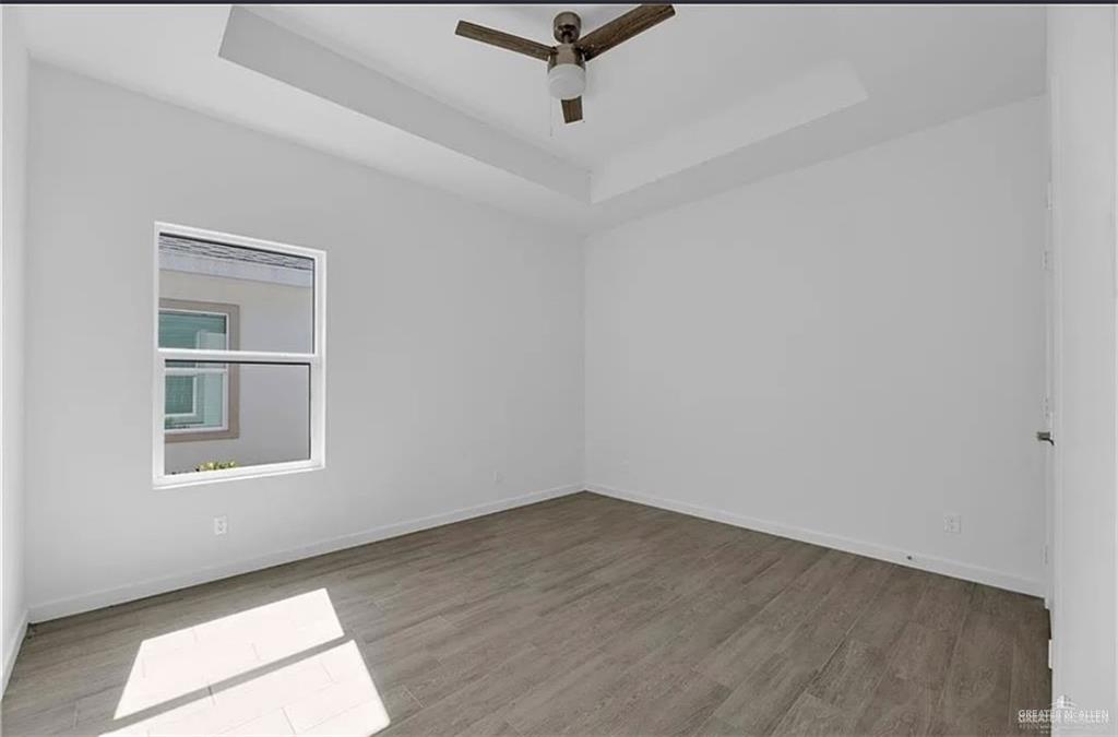 1303 Marcela Drive, Unit 4 Weslaco, TX 78599 - Photo 10 of 12 Spare room with a tray ceiling, light wood finished floors, and ceiling fan
