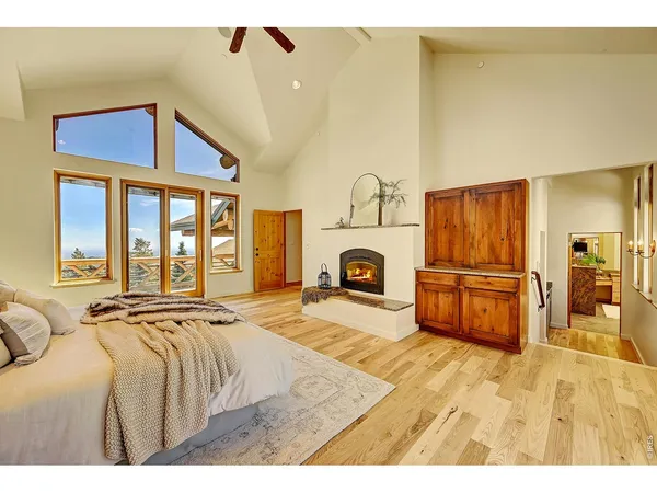 a spacious bedroom with a bed and wooden floor