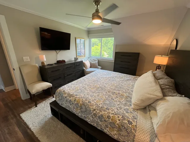 a bedroom with a bed a couch and a flat screen tv