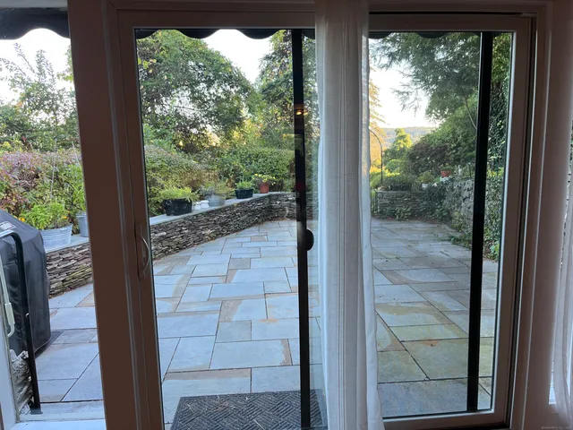 a view of a glass door with a yard from a window