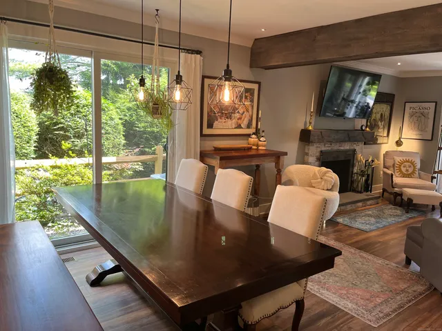 a view of a dining room with furniture a chandelier and wooden floor