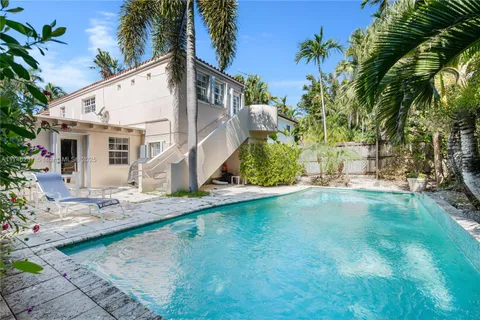 a view of a house with pool and sitting area