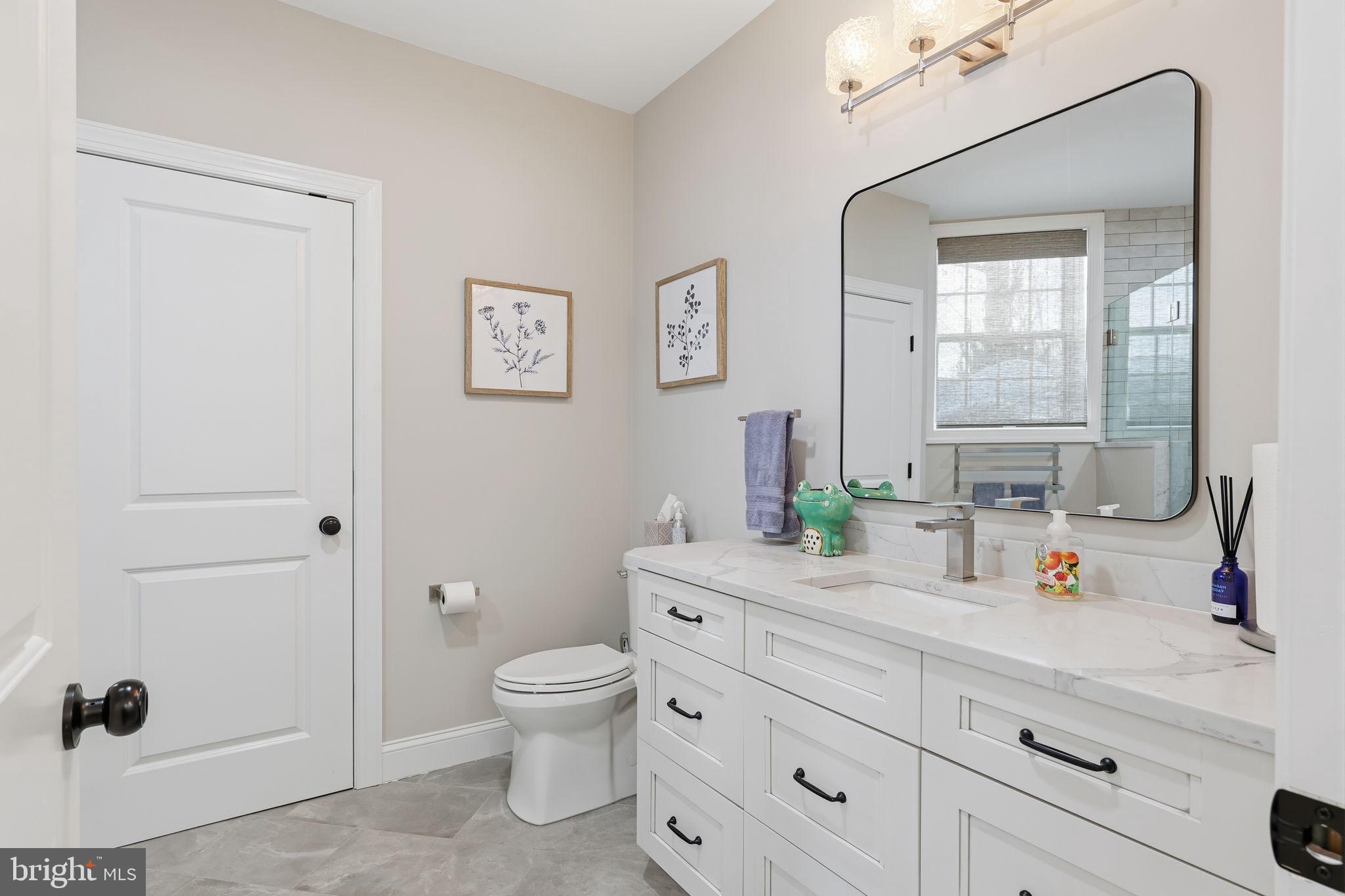 7 Woodland Road Newtown, PA 18940 - Photo 117 of 137 a spacious bathroom with a granite countertop sink a toilet and a mirror