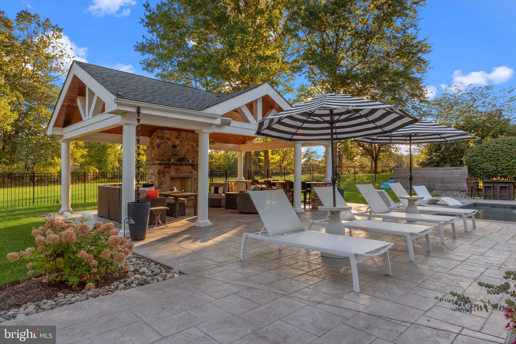 7 Woodland Road Newtown, PA 18940 - Photo 10 of 137 a view of a patio with a table and chairs under an umbrella