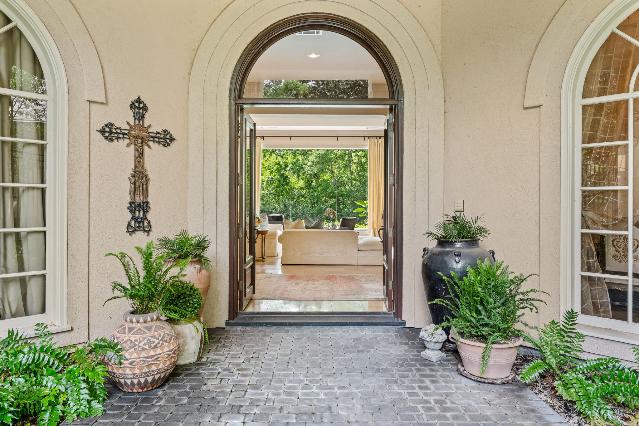6 Mott Lane Houston, TX 77024 - Photo 10 of 50 Inviting arched entryway opens to a warm and light-filled interior, framed by elegant architectural details.