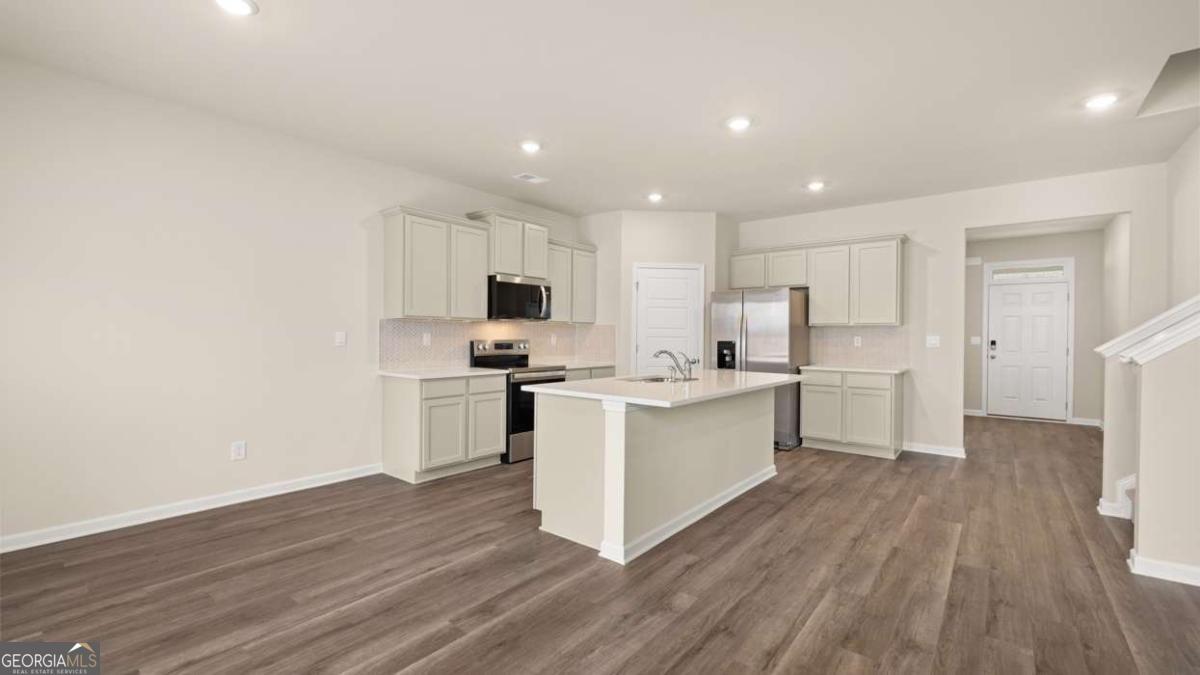 208 Cattle Drive Perry, GA 31069 - Photo 9 of 37 a kitchen with cabinets wooden floor and white appliances