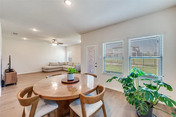 a dining room with furniture and a potted plant