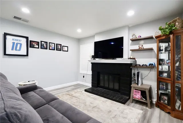 a living room with furniture a flat screen tv and a fireplace
