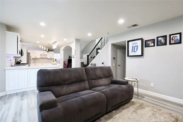 a living room with furniture and a view of kitchen