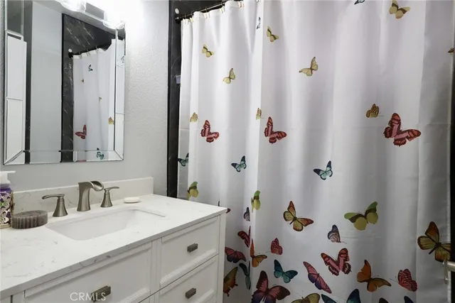 a bathroom with a sink and a mirror with bathtub
