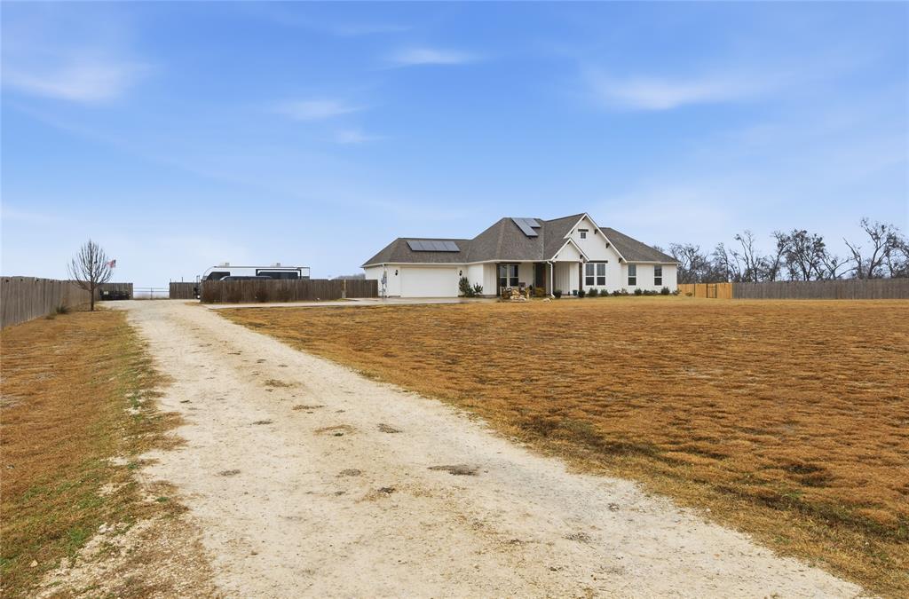 1292 Whiskey Hollow Road West, TX 76691 - Photo 2 of 34 View of front of property with roof mounted solar panels and driveway