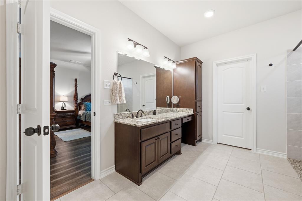 1292 Whiskey Hollow Road West, TX 76691 - Photo 20 of 34 Ensuite bathroom featuring vanity, light tile patterned flooring, and a shower