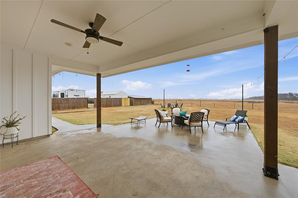 1292 Whiskey Hollow Road West, TX 76691 - Photo 29 of 34 Fenced backyard with ceiling fan, an outdoor hangout area, and a patio