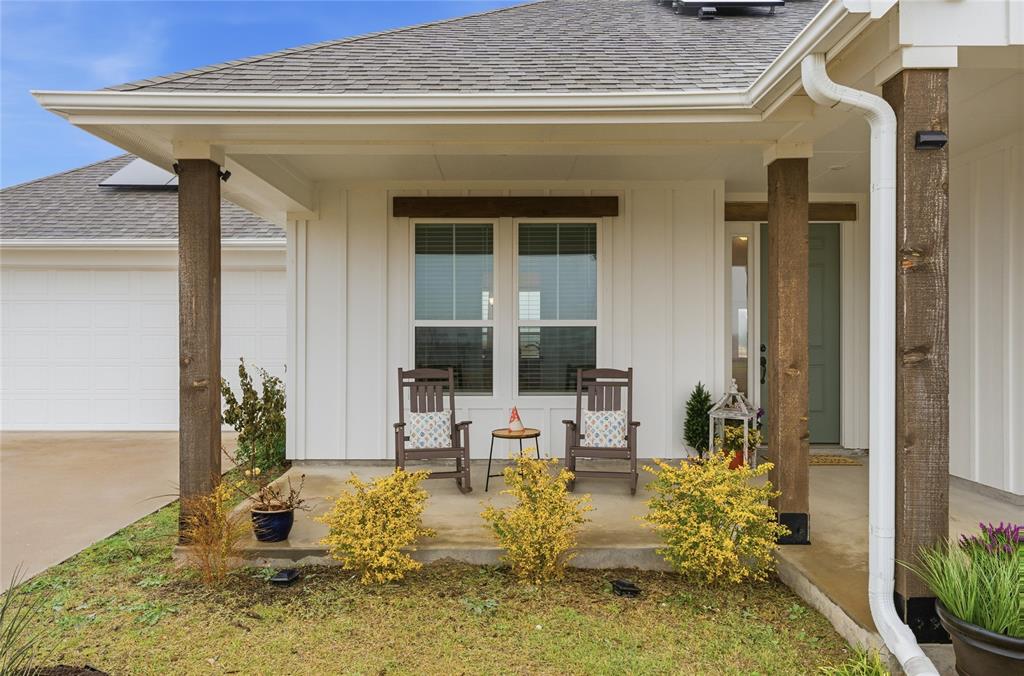 1292 Whiskey Hollow Road West, TX 76691 - Photo 4 of 34 View of exterior entry with roof with shingles, board and batten siding, and covered porch