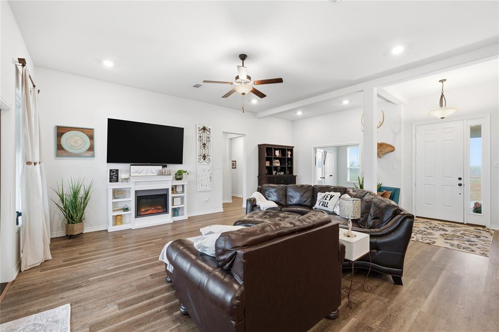 1292 Whiskey Hollow Road West, TX 76691 - Photo 6 of 34 Living room featuring wood finished floors, ceiling fan, a glass covered fireplace, and recessed lighting