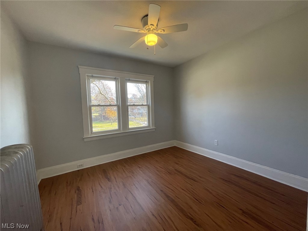 924 Richmond Road Cleveland, OH 44124 - Photo 23 of 34 Spare room with radiator heating unit, dark hardwood / wood-style floors, and ceiling fan