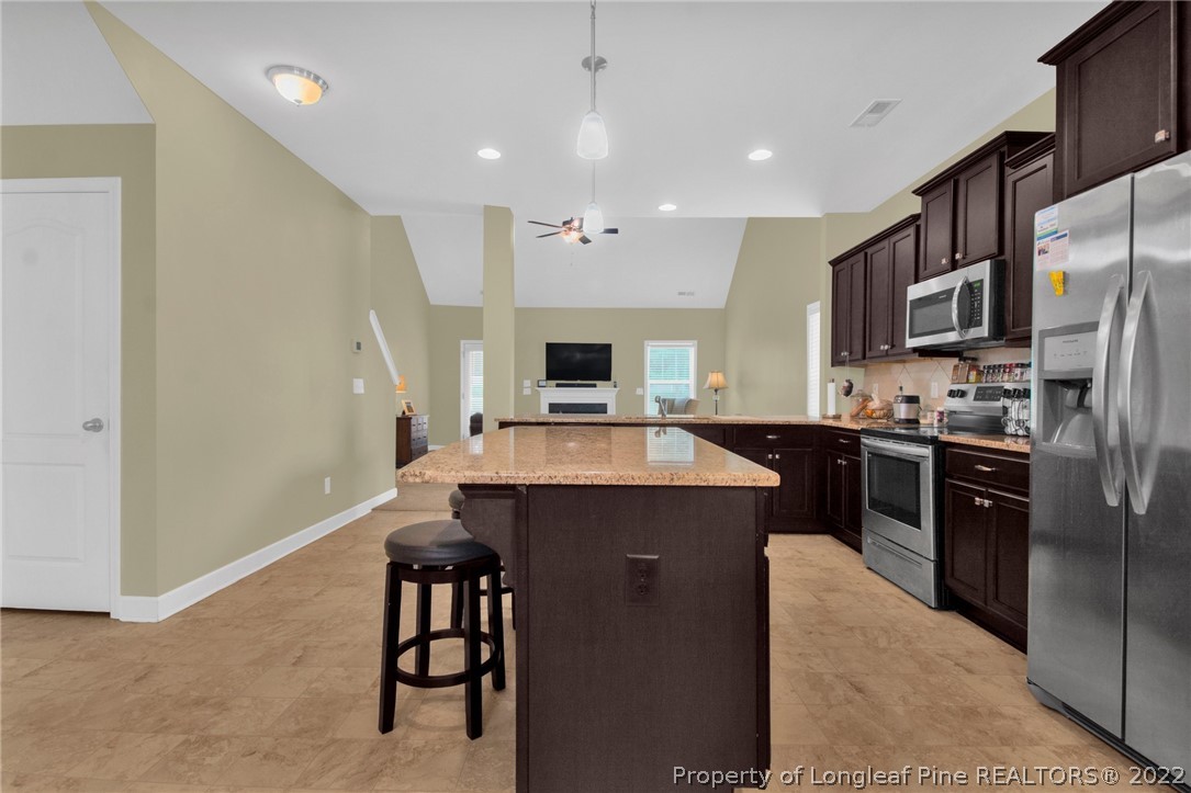 809 Montrose Road Raeford, NC 28376 - Photo 8 of 33 a kitchen with a refrigerator a oven a sink a dining table and chairs