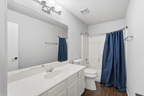 an empty room with a ceiling fan and a carpet