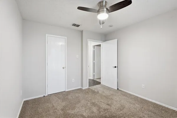 a view of backyard with potted plants and wooden fence