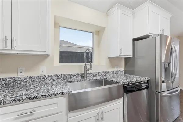 a kitchen with stainless steel appliances granite countertop a refrigerator and a sink
