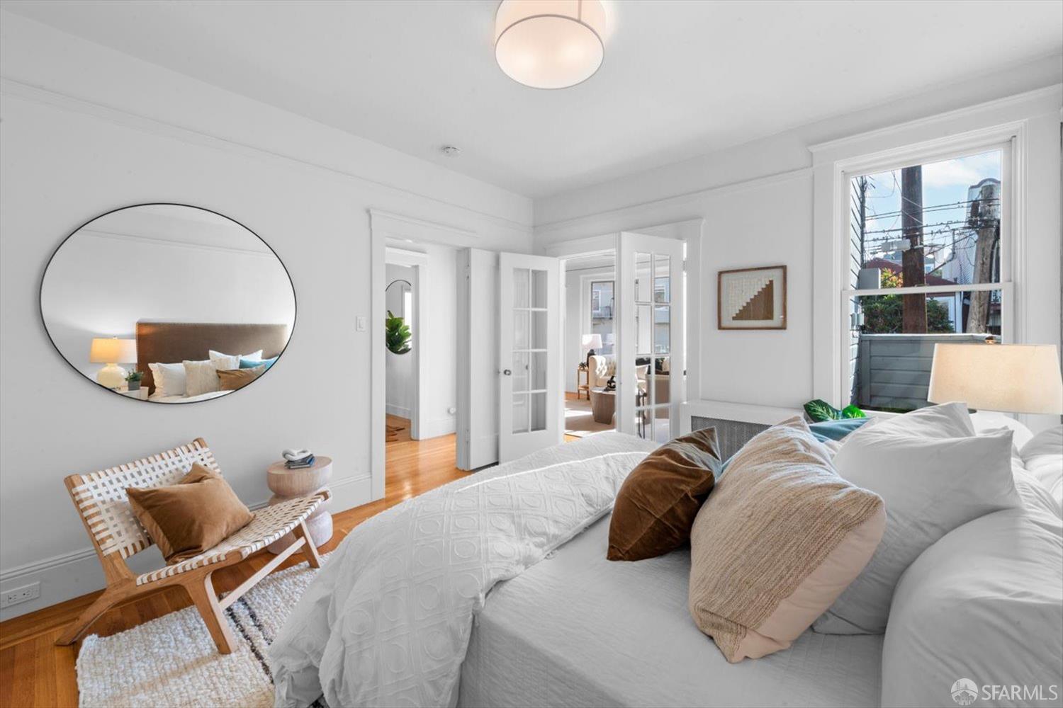 1624 Filbert Street, Unit 1 San Francisco, CA 94123 - Photo 30 of 47 a bedroom with bed a mirror and a large window