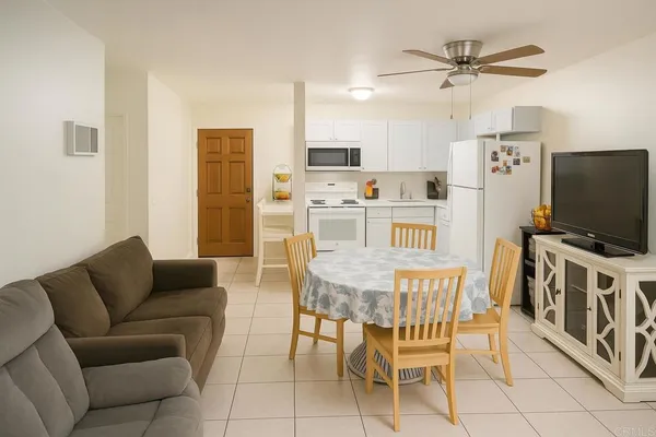 a living room with furniture a flat screen tv and kitchen view