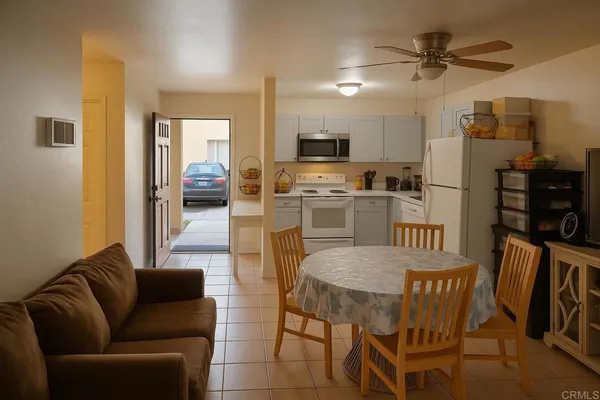 a living room with furniture a dining table and chairs with wooden floor