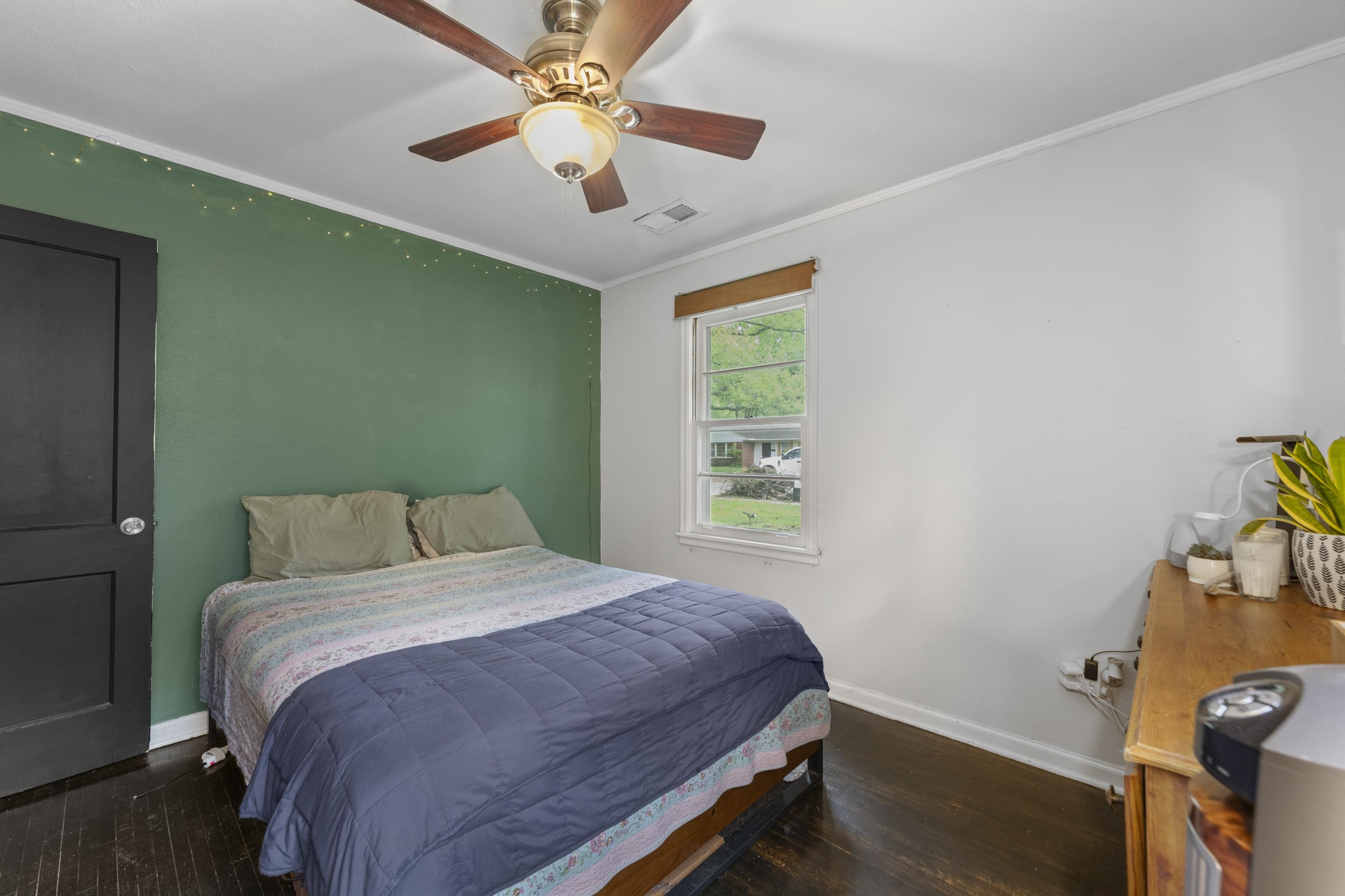 1343 Dearing Road Memphis, TN 38117 - Photo 17 of 19 Bedroom featuring a ceiling fan with integrated lighting, wood-finish flooring, a single window, and a dark-painted interior door
