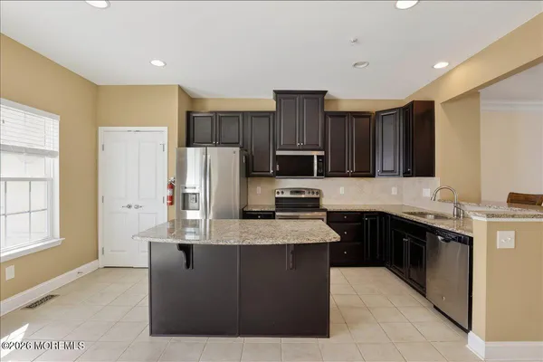 a kitchen with stainless steel appliances granite countertop a refrigerator stove and a sink