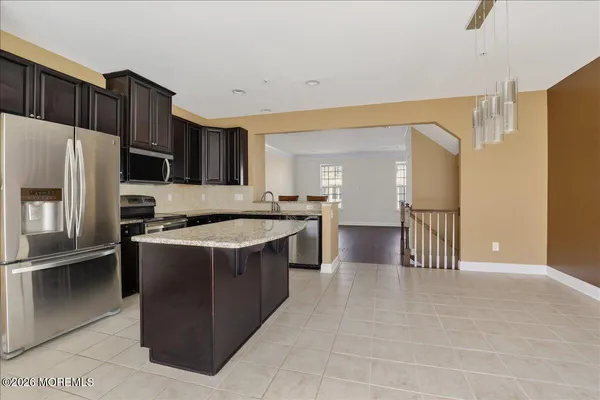 a large kitchen with a large counter top stainless steel appliances and cabinets