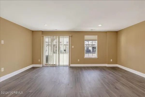 a view of an empty room with wooden floor