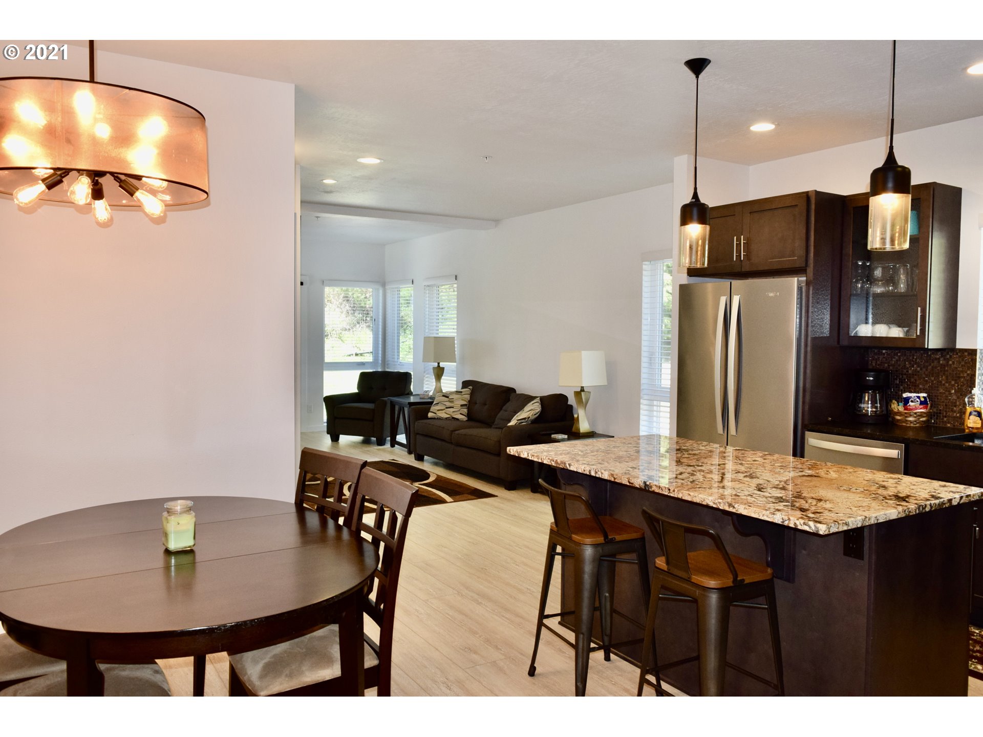 94353 Leith Road Gold Beach, OR 97444 - Photo 18 of 30 a kitchen with stainless steel appliances kitchen island granite countertop a table chairs and a refrigerator