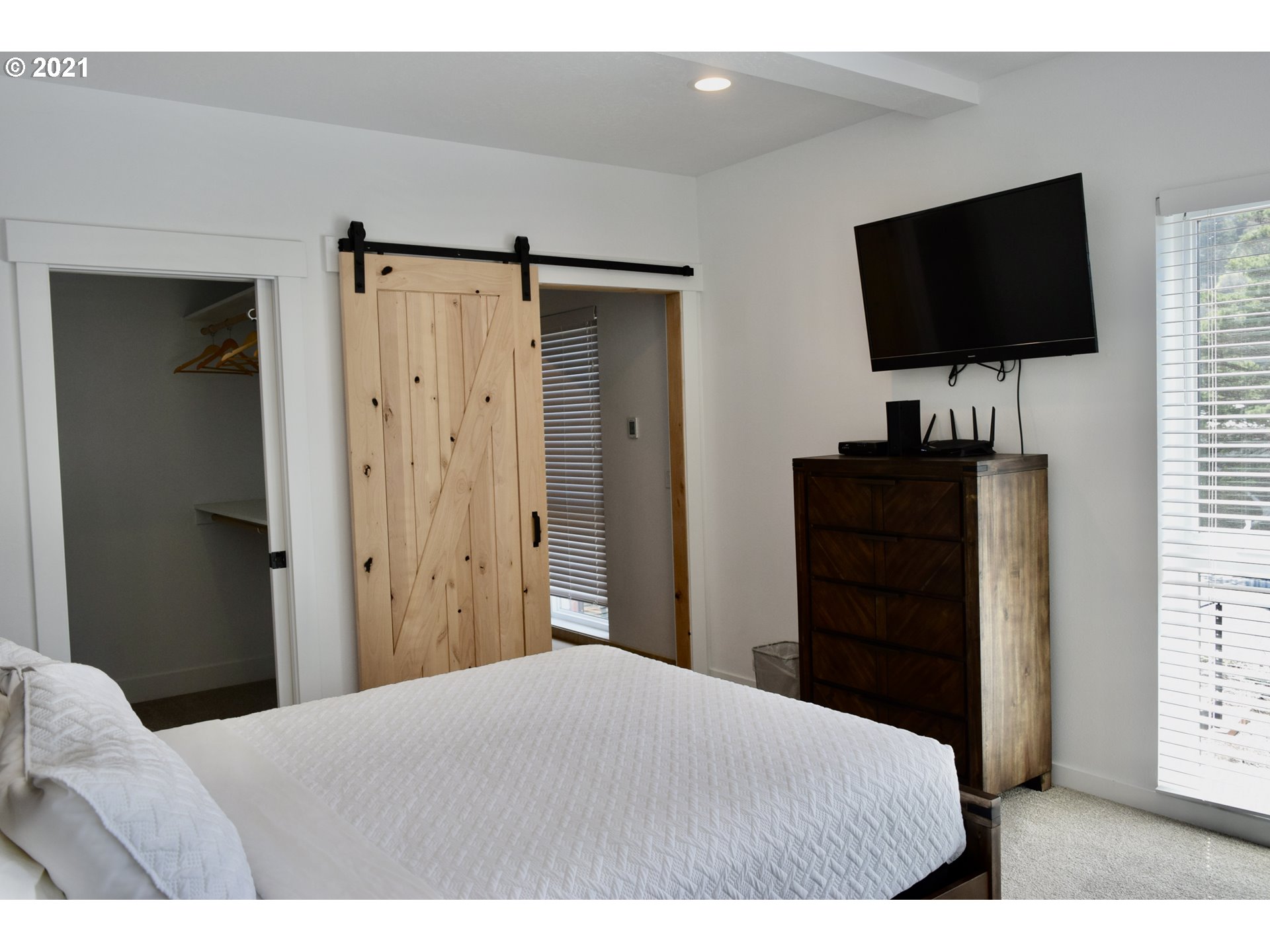 94353 Leith Road Gold Beach, OR 97444 - Photo 29 of 30 a bedroom with a bed and a flat tv screen on dresser