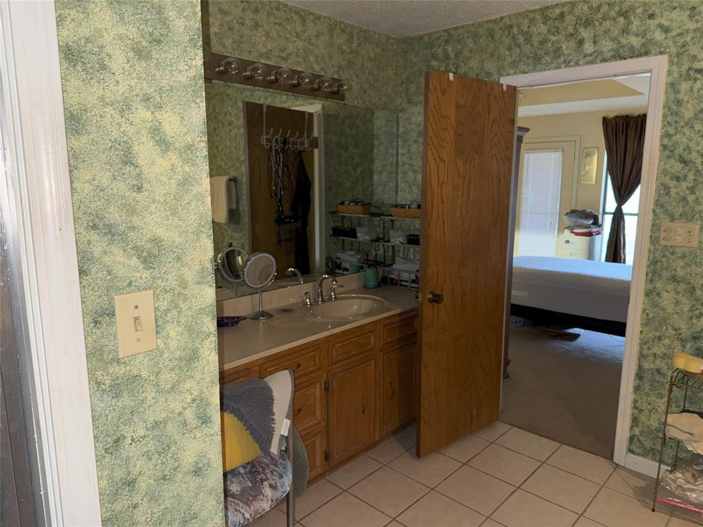 522 Twin Point Drive Benton, LA 71006 - Photo 31 of 33 Full bath featuring wallpapered walls, light tile patterned floors, vanity, ensuite bathroom, and a textured ceiling