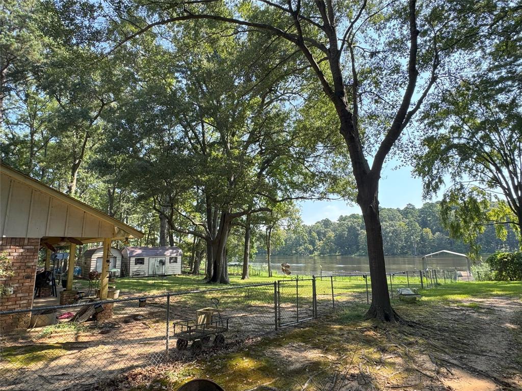 522 Twin Point Drive Benton, LA 71006 - Photo 8 of 33 View of yard with a water view, a patio, a gate, view of scattered trees, and an outdoor structure
